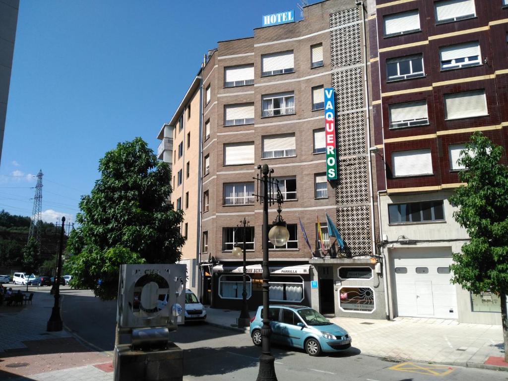 une voiture est garée devant un bâtiment dans l'établissement Hotel Vaqueros, à Langreo