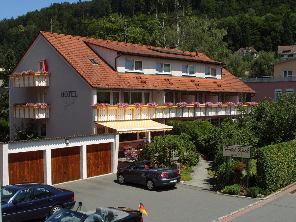 ein Haus mit einem Auto auf einem Parkplatz in der Unterkunft Hotel Koch in Bad Liebenzell