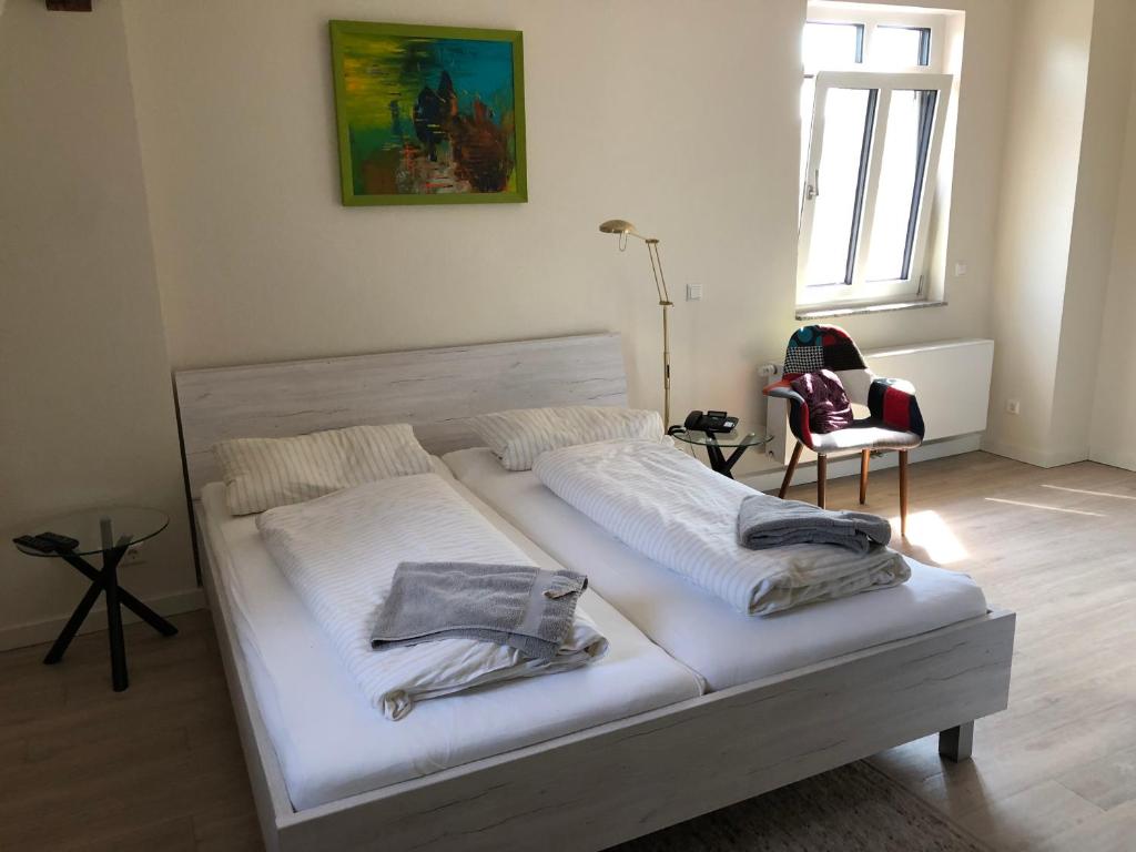 Una cama blanca con toallas en una habitación en Haus am See, en Berlín