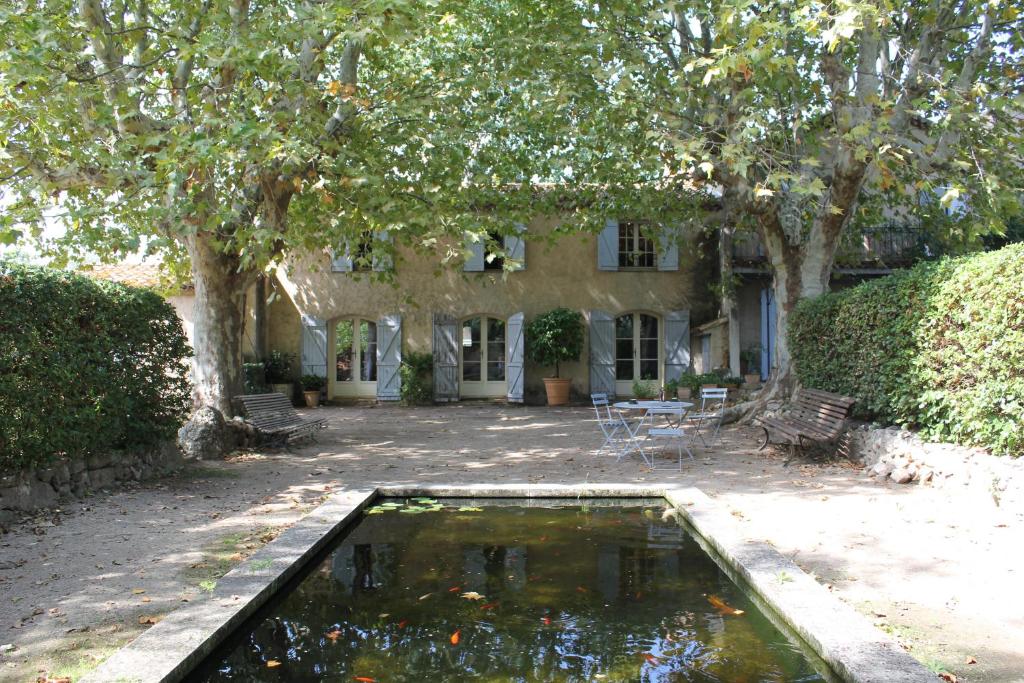 una piscina de agua frente a una casa en La Gracette en Aix-en-Provence