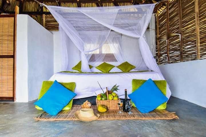 a bed with a canopy in a room at Ecohotel Kocoluu in San Bernardo del Viento