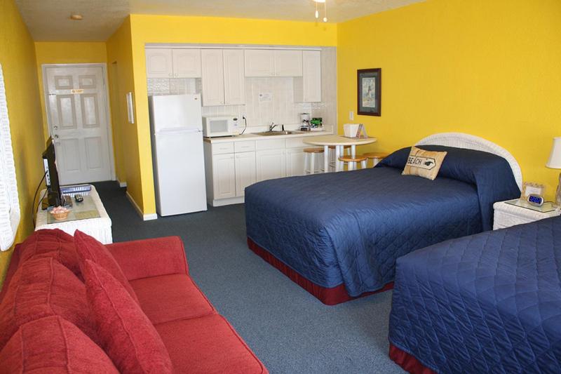 a hotel room with two beds and a kitchen at Barefoot Bay Resort Motel in Clearwater Beach
