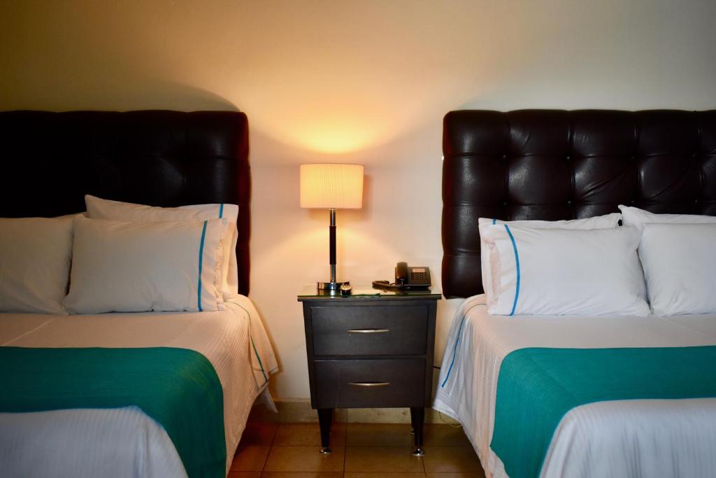 Postel nebo postele na pokoji v ubytování Country Hotel & Suites
