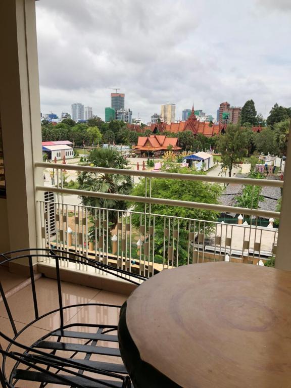 a balcony with a table and a view of a city at The Bright Lotus Guesthouse in Phnom Penh