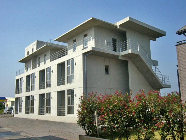 un gran edificio blanco con un balcón en la parte superior. en SR Mansion, en Kanoya