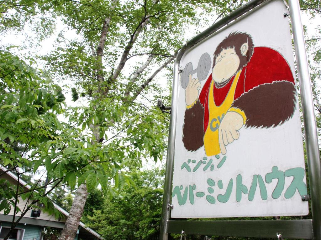 a sign with a picture of a monkey on it at Pension Peppermint House in Hara