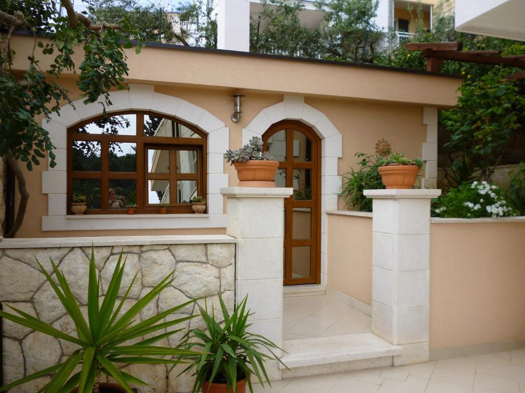 a house with a front door with potted plants at Apartments Jani in Hvar