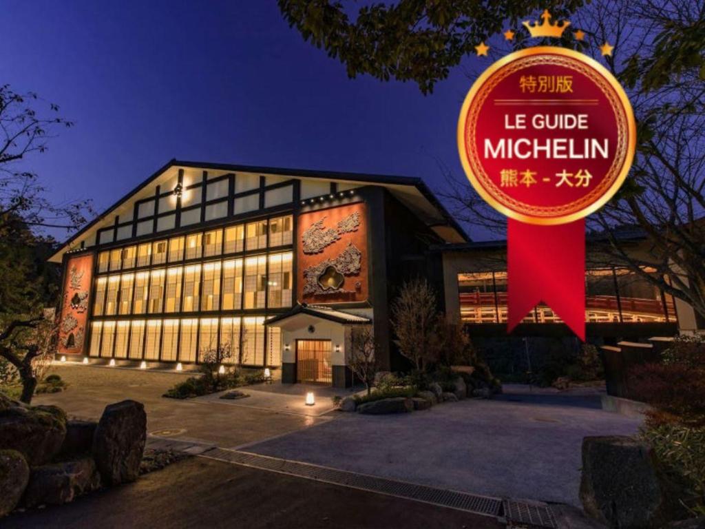 un bâtiment avec un panneau rouge devant lui dans l'établissement Okuhita Onsen Umehibiki, à Hita