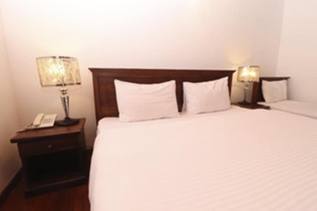 Postel nebo postele na pokoji v ubytování Daffodil's Hotel