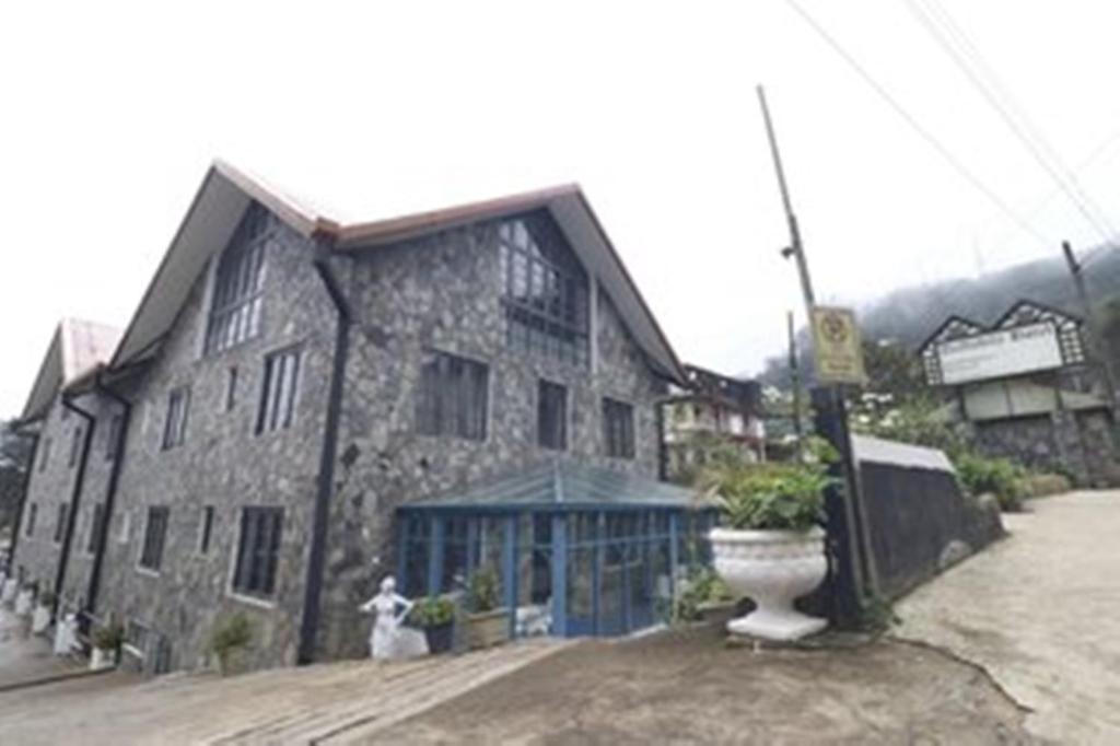 a large stone building with a dog in front of it at Daffodil's Hotel in Nuwara Eliya