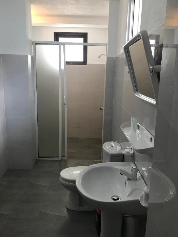 a bathroom with a toilet and a sink and a mirror at Unawatuna Beach Bungalow - in Unawatuna