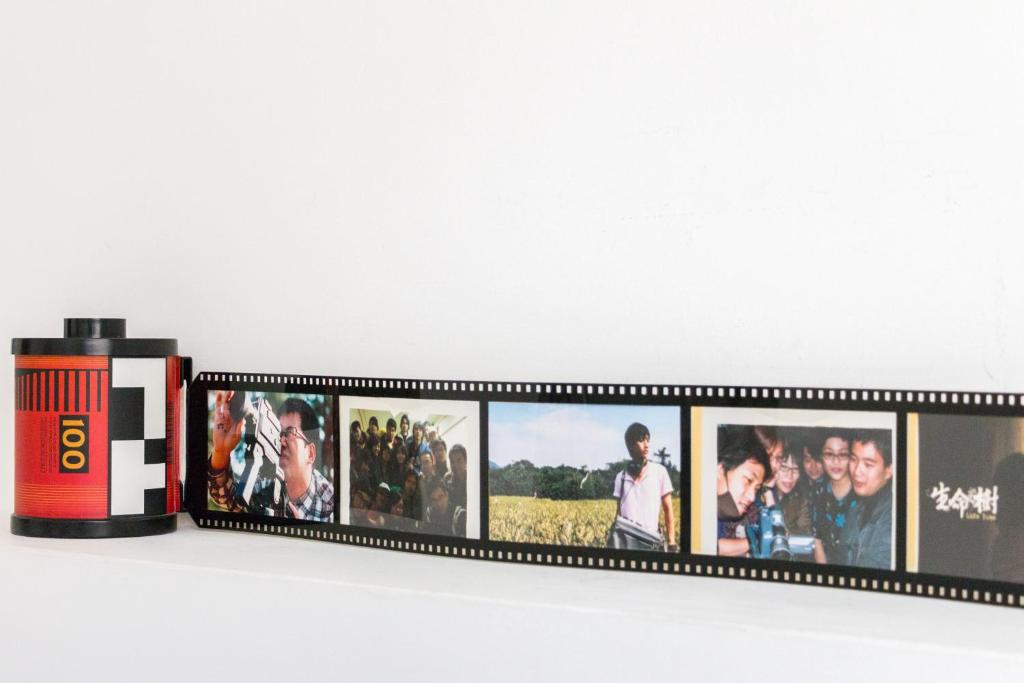 a shelf with a group of photos on it at Ciao Life B&amp;B in Taitung City