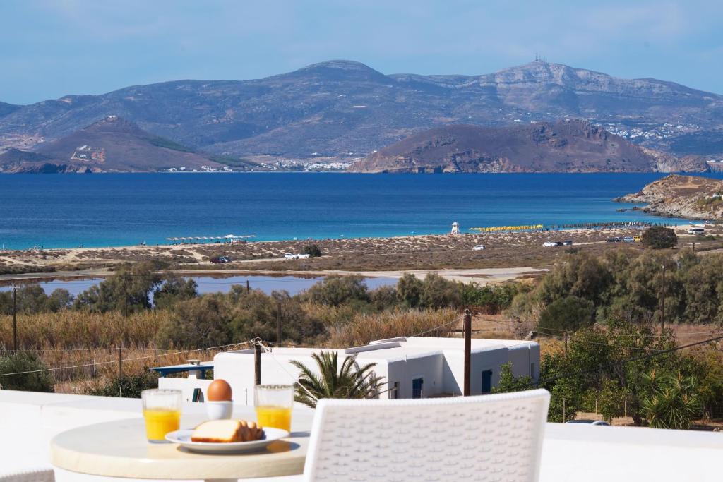 a table with a plate of food and a view of the ocean at Camara Hotel in Agios Prokopios