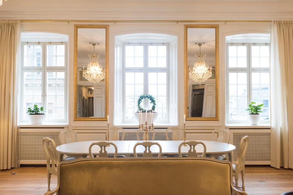 a dining room with a table and chairs and windows at Hotel Kungsträdgården in Stockholm