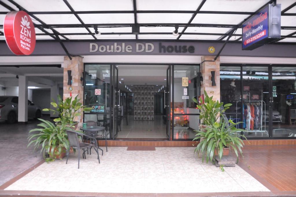 a restaurant with tables, chairs, and umbrellas at Double DD House at MRT Sutthisarn in Bangkok