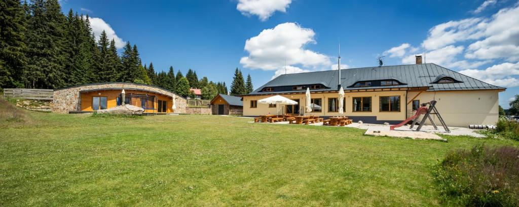dom z trawnikiem przed nim w obiekcie EA Horský Hotel Hájenka w mieście Modrava