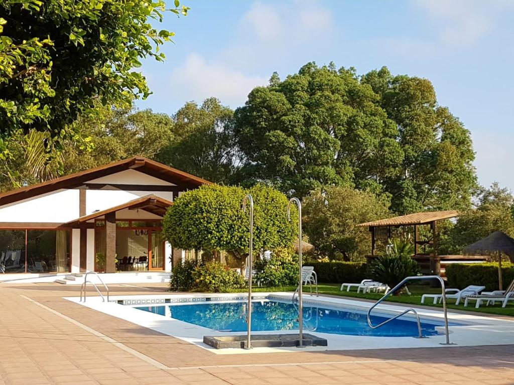 a swimming pool in a yard with a pavilion at Hotel El Paso in Vejer de la Frontera