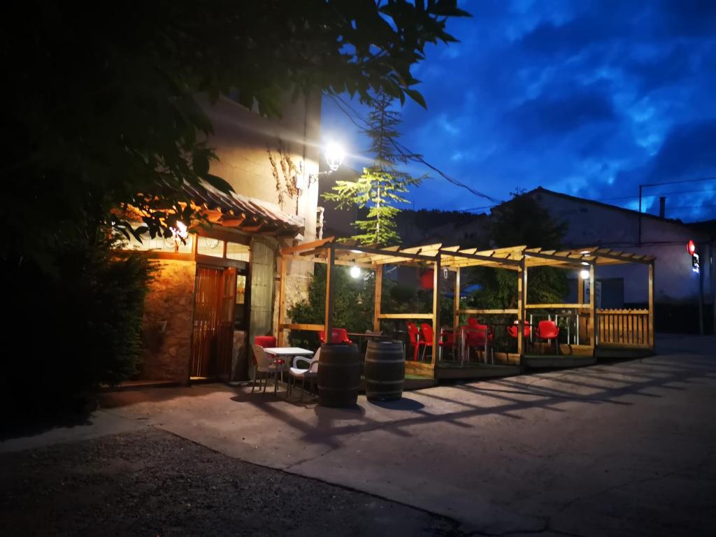 un patio con tavolo e sedie di notte di Hospedaje Rural Casa Parri a Poveda de la Sierra