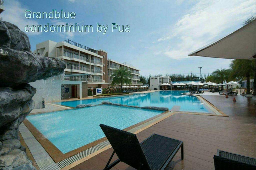 a large swimming pool in front of a hotel at Grandblue condominium 106,302 in Mae Pim