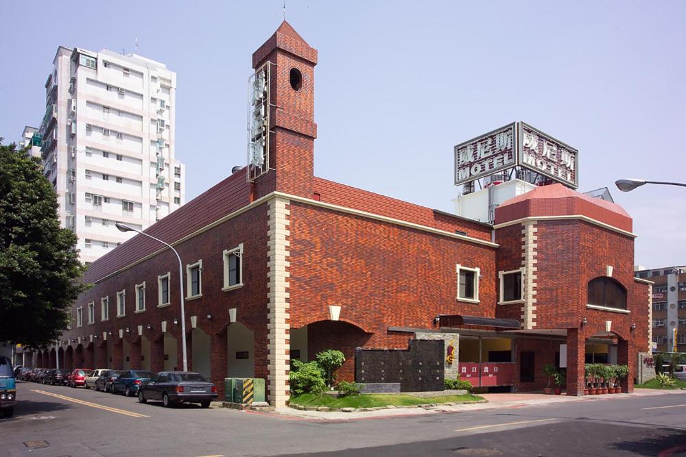 un grand bâtiment en briques rouges avec une tour d'horloge. dans l'établissement Venice Motel, à Kaohsiung