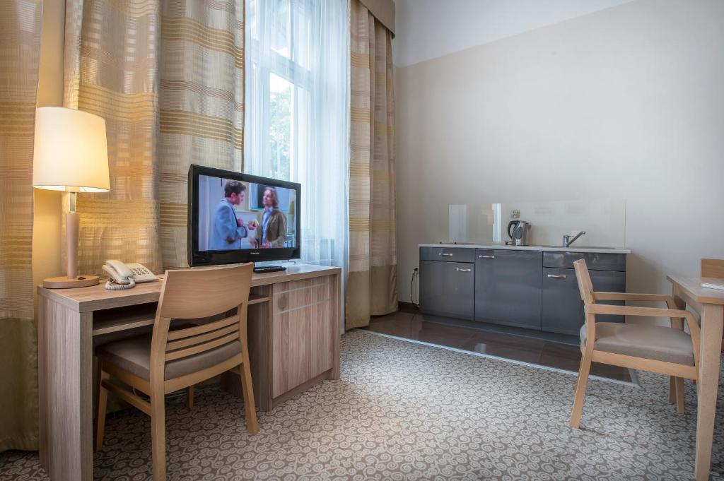 Televízia a/alebo spoločenská miestnosť v ubytovaní Hotel Cesarskie Ogrody