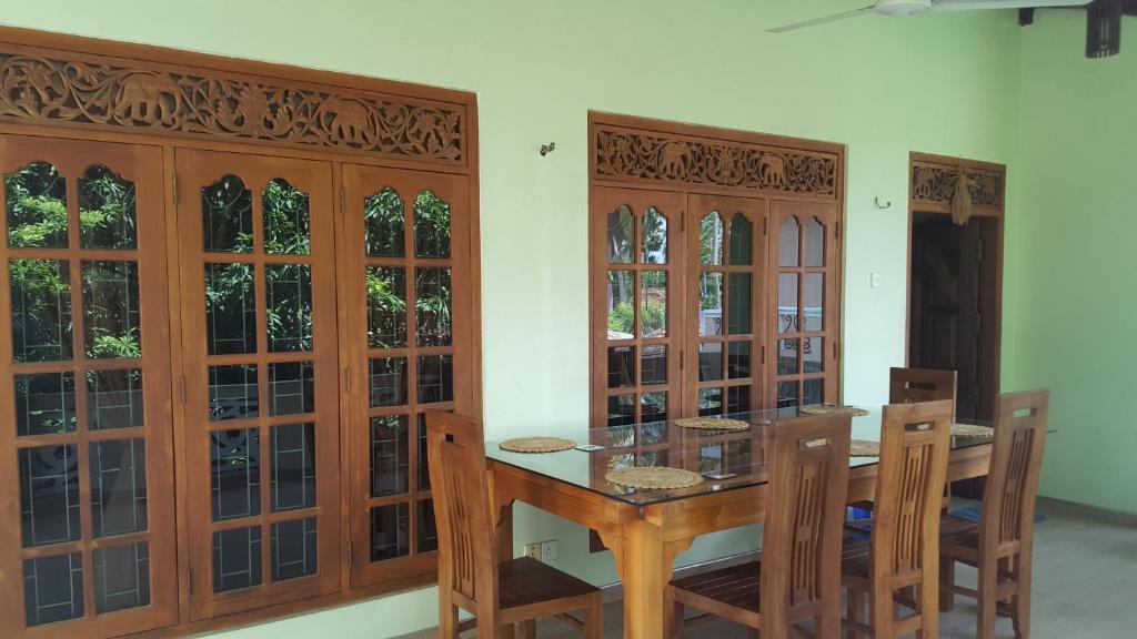 a dining room with wooden cabinets and a table and chairs at Kavindi Villa in Beruwala