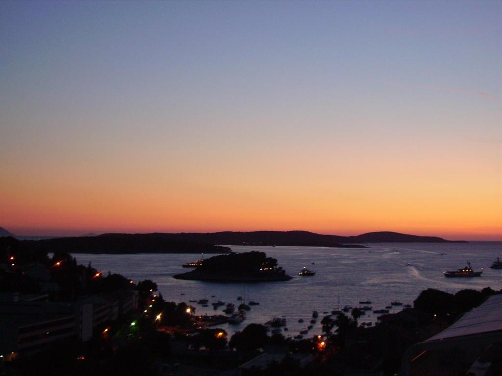 a sunset over the water with boats in it at Apartments Jani in Hvar