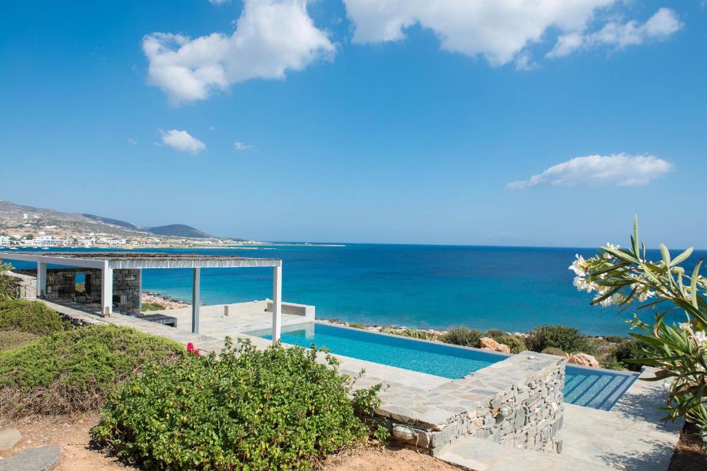 a villa with a swimming pool next to the ocean at Luxury Villa Seafront in Aliki