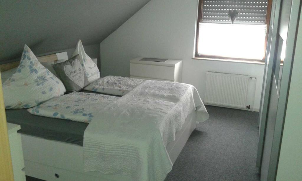 a bedroom with a white bed and a window at Komfort_Ferienwohnung in Geldern