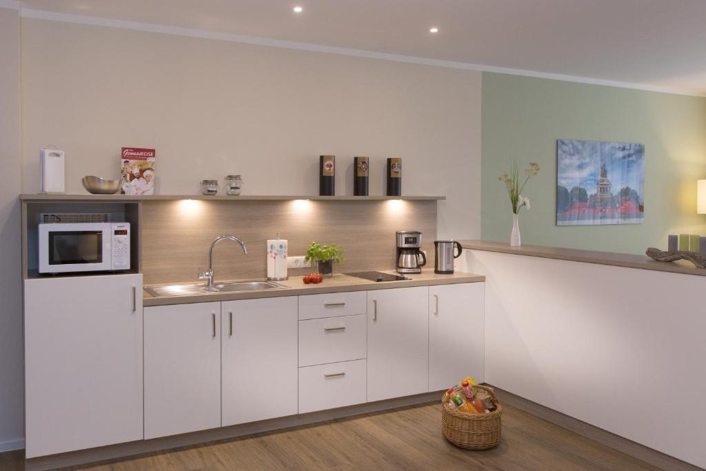 a kitchen with white cabinets and a sink at Cozy-Flats Koblenz in Koblenz