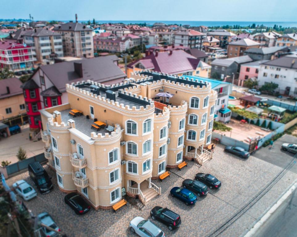 a large building with cars parked in a parking lot at Guest House Zamok u morya in Vityazevo