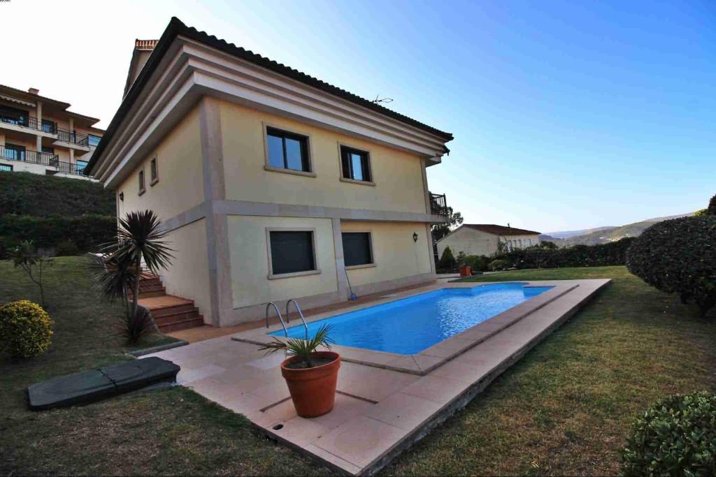 dom z basenem przed nim w obiekcie Casa de O Rosal w mieście San Bartolomé
