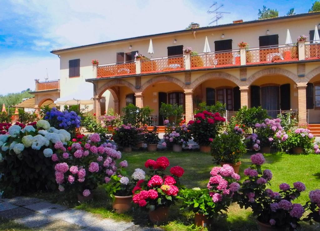 un giardino di fiori di fronte a un edificio di Hotel Le Renaie a San Gimignano