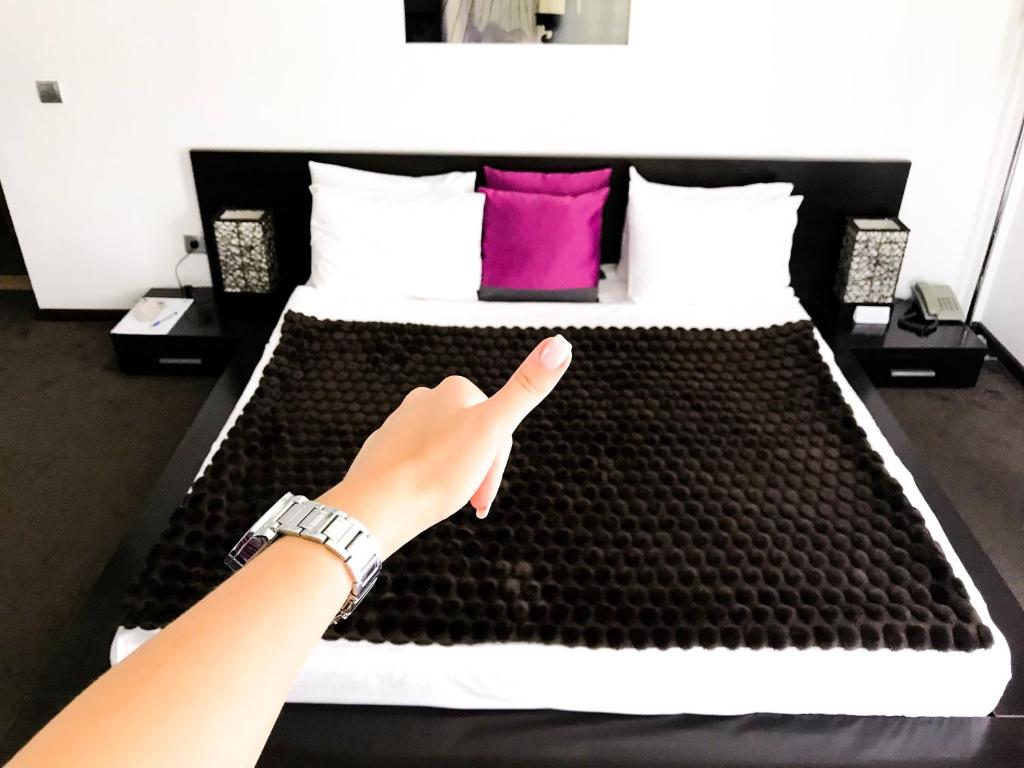 a person reaching for a bed in a room at SPA Hotel in Vorzel