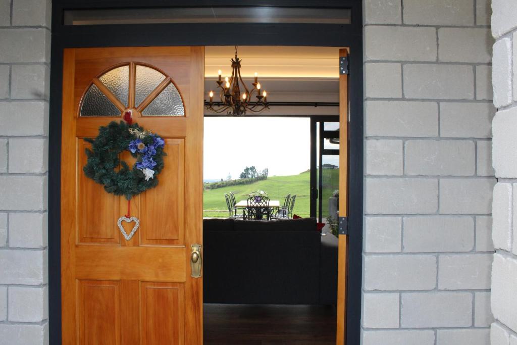 a door with a wreath on it next to a table at Arohanui Rural Retreat B&B in Tauranga