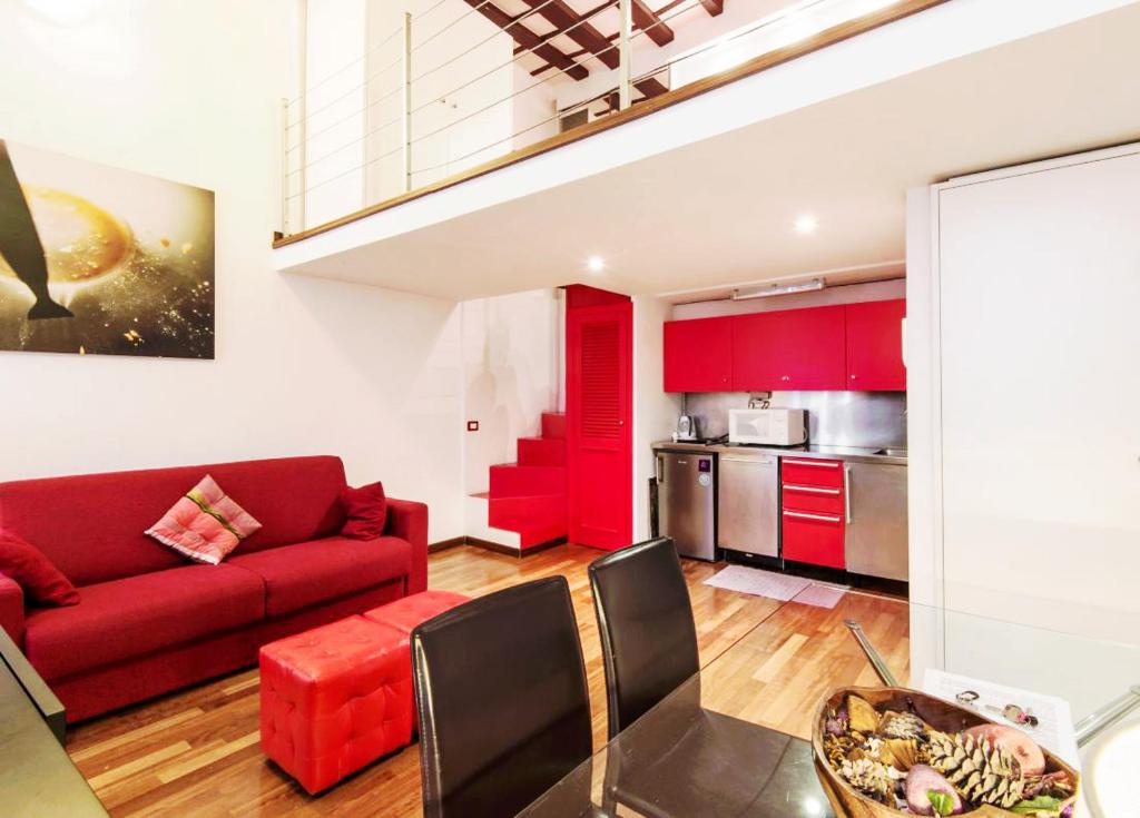 ローマにあるRSH Balestrari Apartmentsのリビングルーム(赤いソファ付)、キッチン