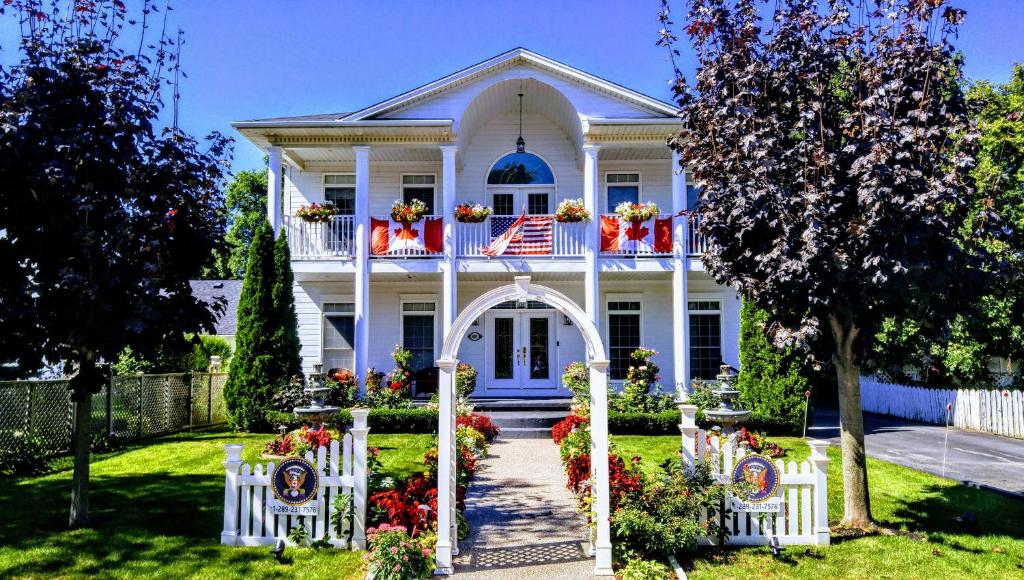 Una casa bianca con una bandiera americana sopra. di The White House Boutique B&B a Niagara on the Lake