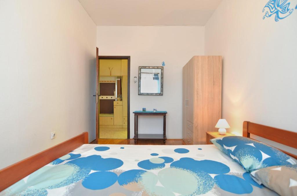 sypialnia z łóżkiem z niebiesko-białą narzutą w obiekcie Apartment Edo 1755 w mieście Peresiji