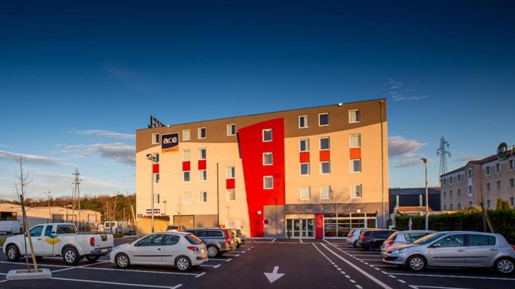 een parkeerplaats met auto's voor een gebouw bij Ace Hotel Valence in Valence