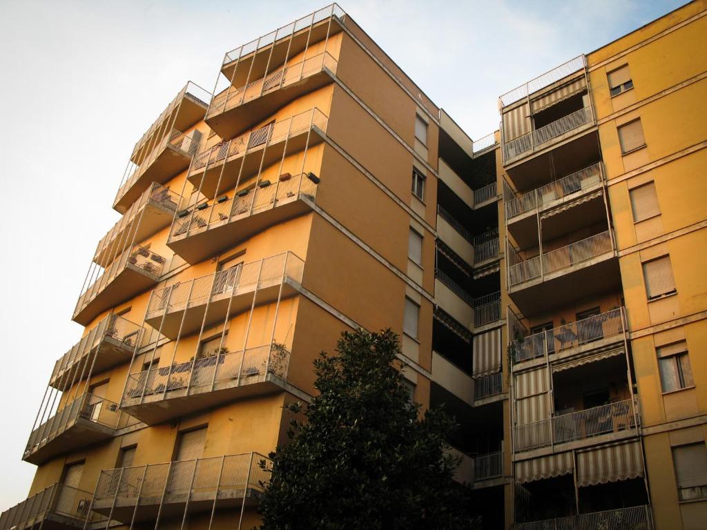 an apartment building with balconies and a tree at B&B Quadrifoglio in Turin