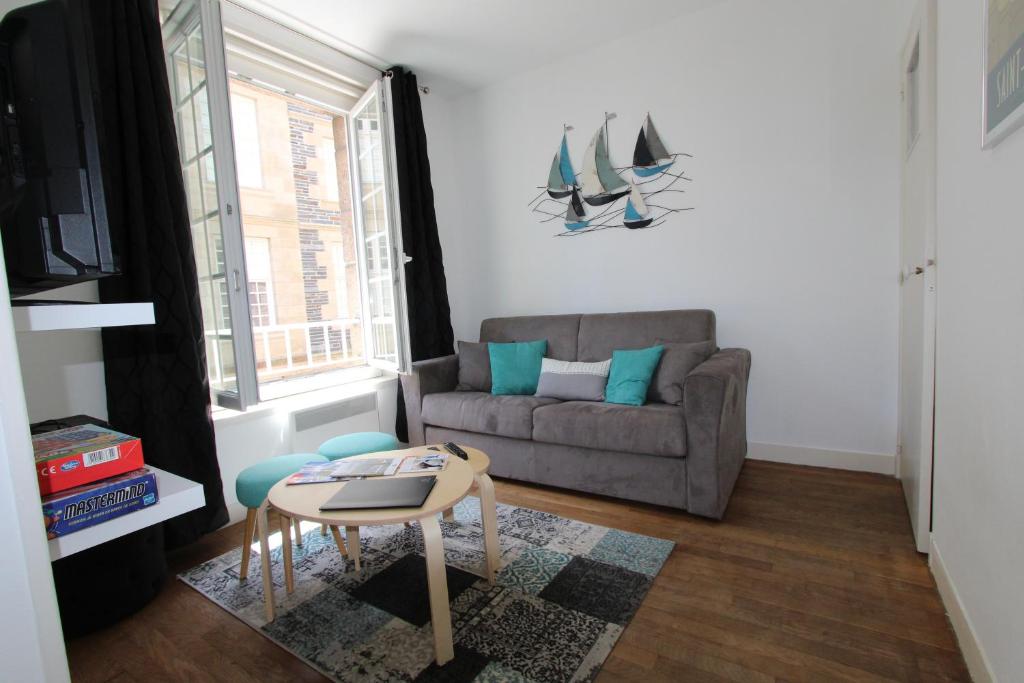 ein Wohnzimmer mit einem Sofa und einem Tisch in der Unterkunft L'Emeraude in Saint-Malo