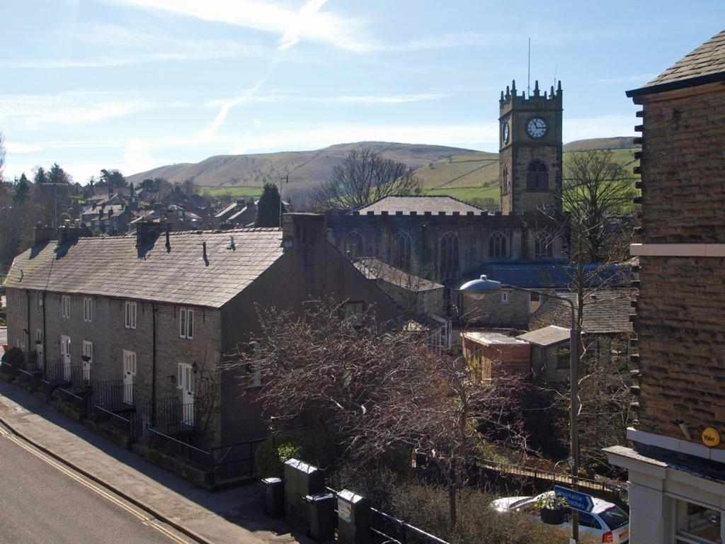 una città con una torre dell'orologio e una chiesa di Drovers Cottage a Hayfield