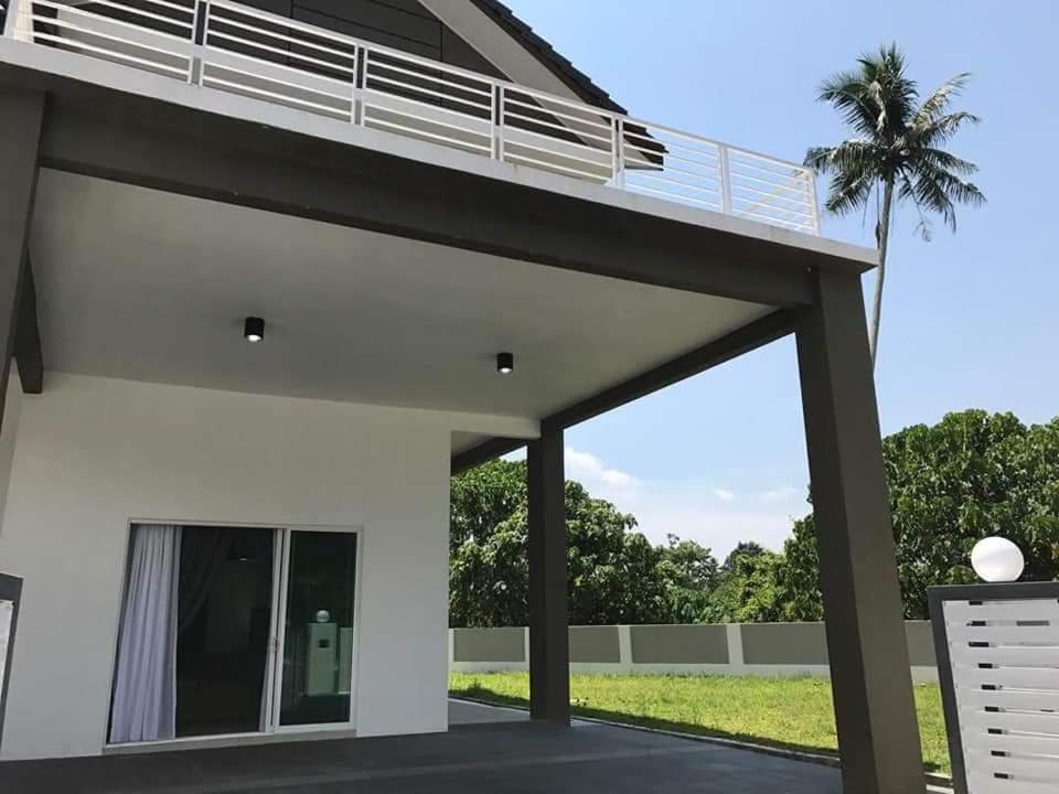a large white house with a patio at Greenville Homestay in Balik Pulau