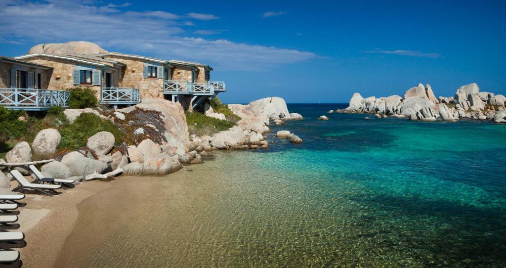 une maison sur une falaise à côté de l'océan dans l'établissement Hotel & SPA des Pecheurs, à Bonifacio