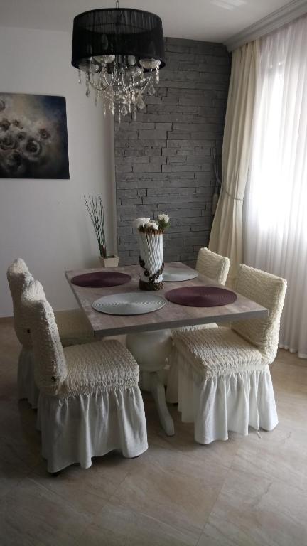 a dining room with a table and chairs and a chandelier at LILI50 in Plovdiv