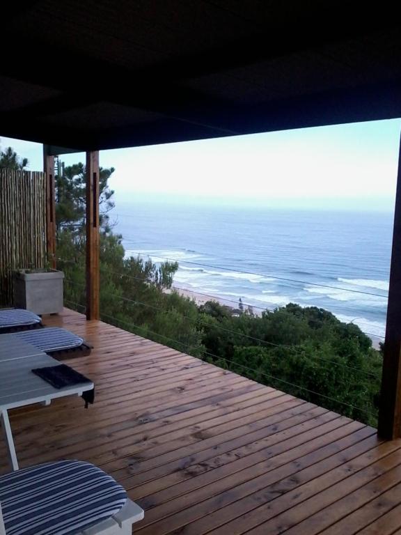 a deck with a view of the ocean from a house at A Wave Song in Wilderness