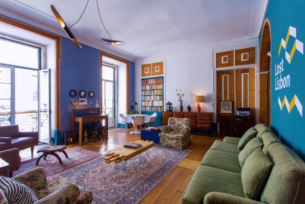 ein Wohnzimmer mit einem grünen Sofa und einer blauen Wand in der Unterkunft Lost Lisbon :: Chiado House in Lissabon