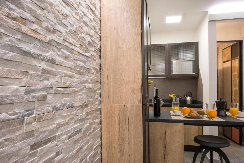 kuchnia z kamienną ścianą i blatem w obiekcie Pitti Apartment we Florencji