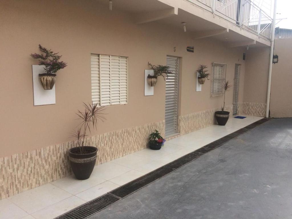 Condomínio DINASEG في ريو برانكو: مجموعة من النباتات الفخارية على جانب المبنى