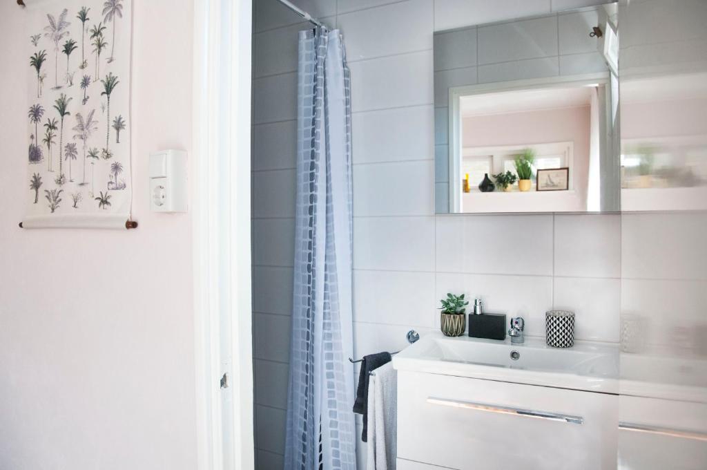 a white bathroom with a sink and a mirror at Heerlijk Huis aan het IJsselmeer in Stavoren